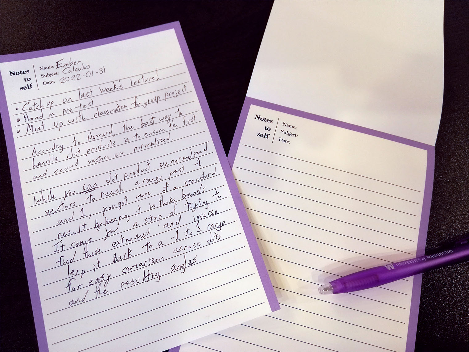 A medium-sized notepad with a pen and a separate page resting on top. Many illegible notes are taken on the separate page.